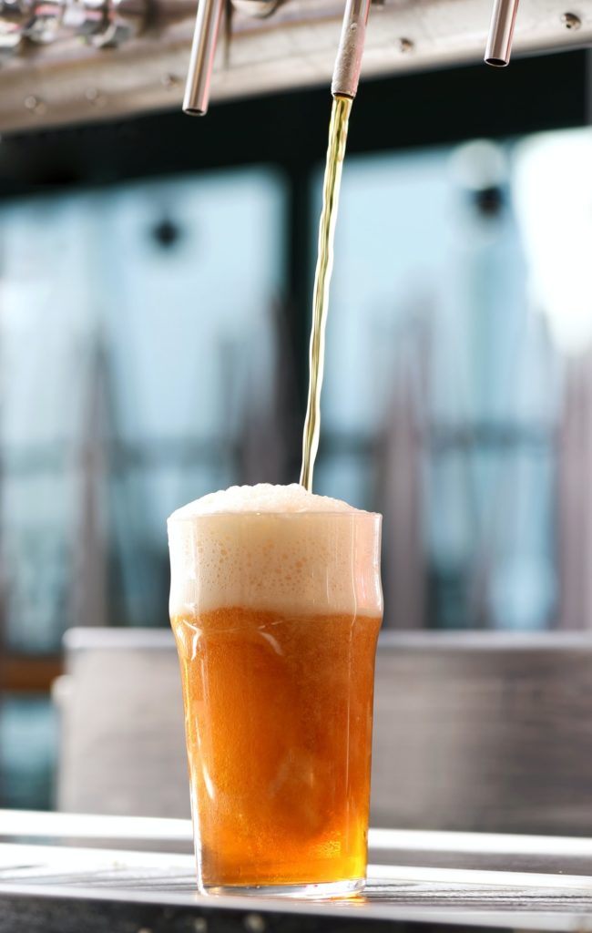 Drafting a glass of beer from a tap in a pub